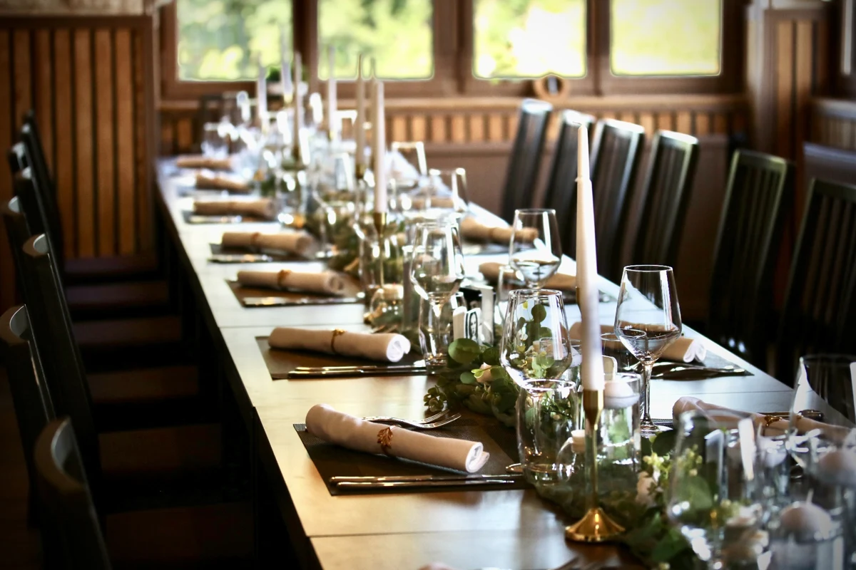 Une grande table dressée pour accueillir un groupe à l’auberge